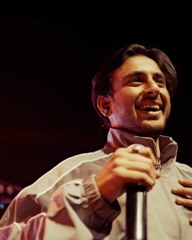 Hasan Raheem smiling on stage, hand on his heart