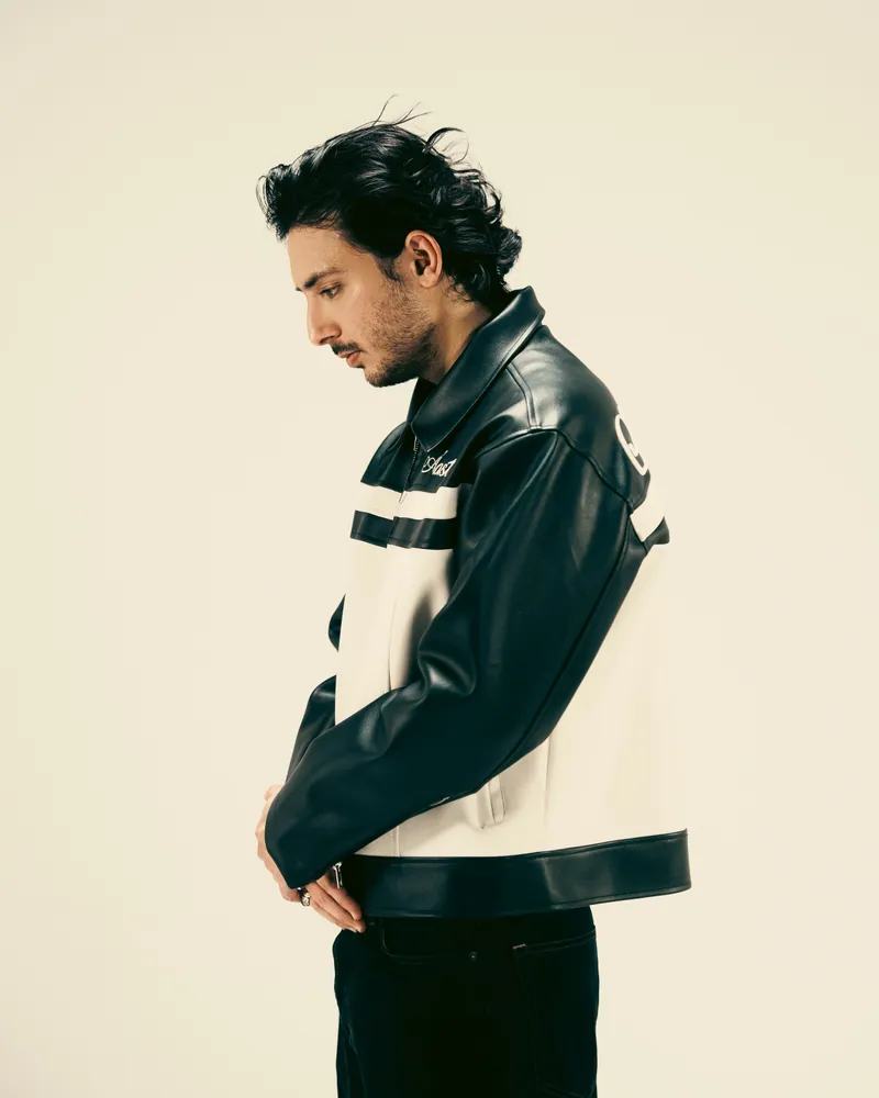 Hasan Raheem in profile wearing a black and cream leather jacket